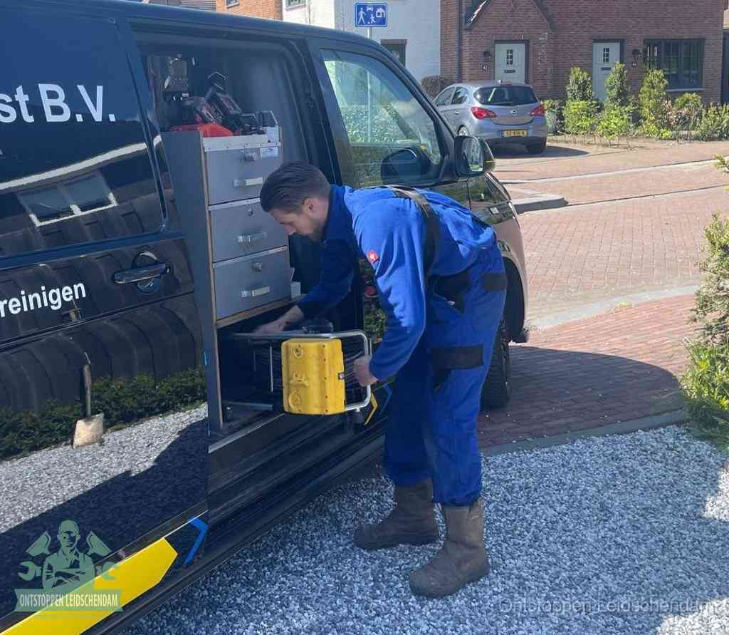 Een monteur pakt gereedschap uit de bedrijfsbus, het moment om een professionele ontstoppingsdienst in te schakelen in Leidschendam